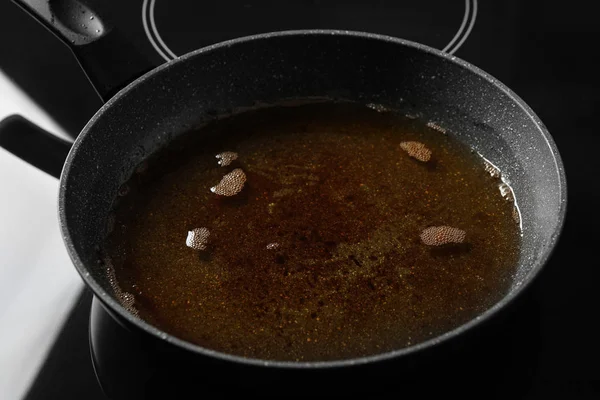 Used cooking oil in frying pan on stove