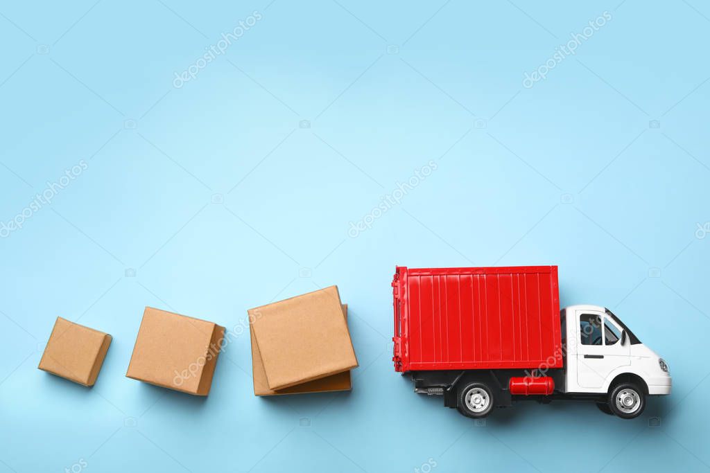 Top view of toy truck with boxes on blue background. Logistics and wholesale concept