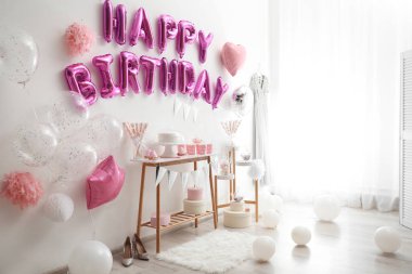 Dekorasyon odasındaki pembe balon mektuplarından oluşan mutlu yıllar.