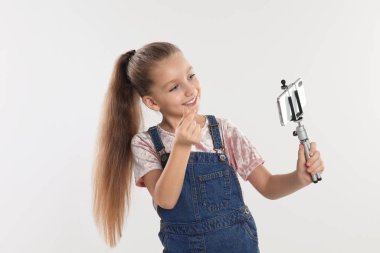 Beyaz arkaplanda video kaydeden sevimli küçük blogger