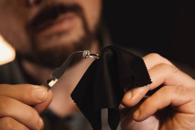 Jeweler working with ring on blurred background, closeup