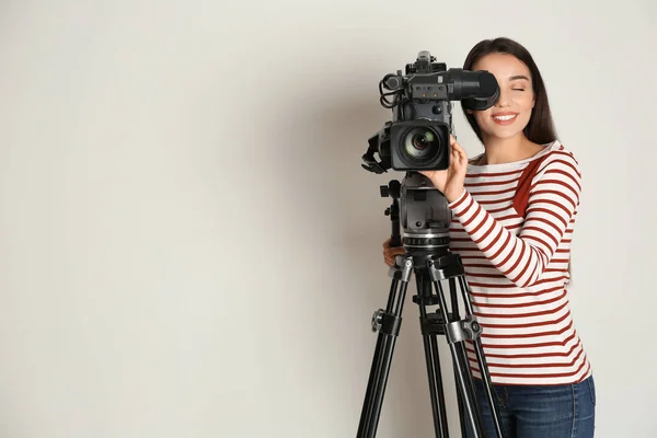 Operatör med professionell videokamera på vit bakgrund, spa — Stockfoto