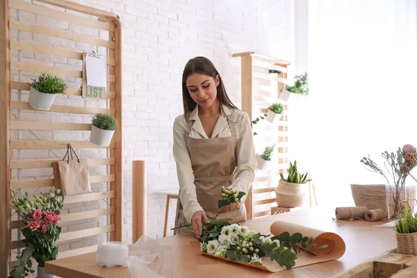 Çiçekçi atölyede güzel bir buket yapıyor.