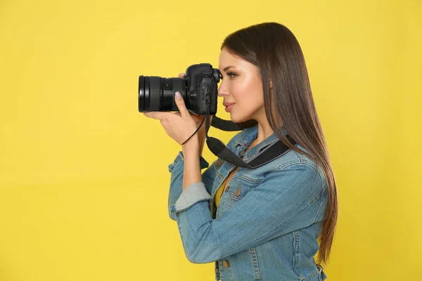 Profesionální fotograf pracující na žlutém pozadí ve studiu — Stock fotografie