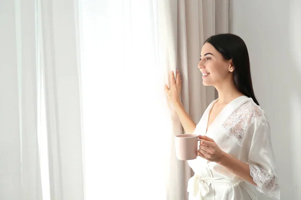 창문 근처에서 커피를 마시고 있는 젊은 여성. 게으른 아침 — 스톡 사진