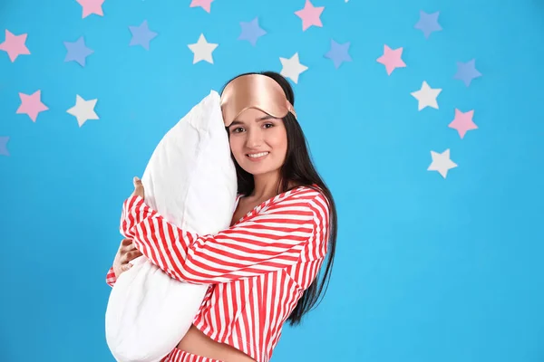 Beautiful woman with pillow on light blue background. Bedtime — Stock Photo, Image