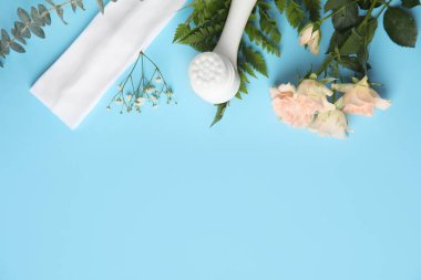 Açık mavi arkaplan üzerinde yüz temizleyici fırça ile düz kompozisyon, metin için boşluk. Kozmetik aksesuar