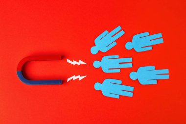 Kırmızı zemin üzerinde mıknatıs ve kağıt insanlar düz yatıyordu