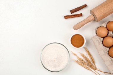 Düz kompozisyon, çiğ yumurta ve diğer malzemeler beyaz masa üzerinde, yazı için boşluk. Pasta yapmak.
