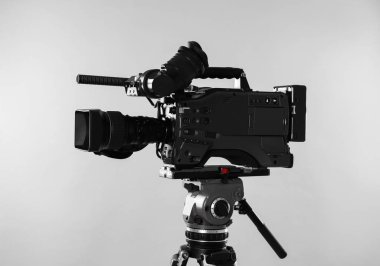 Işık arkaplanındaki modern profesyonel video kamera