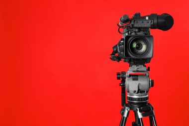 Kırmızı arka planda modern profesyonel video kamera. Metin için boşluk