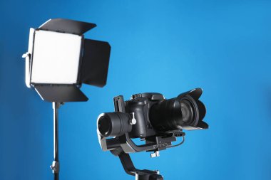 Mavi arka planda profesyonel video kamera ve ışıklandırma ekipmanları