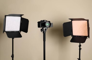 Bej arka planda profesyonel video kamera ve ışıklandırma ekipmanları