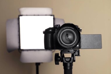 Bej arka planda profesyonel video kamera ve ışıklandırma ekipmanları