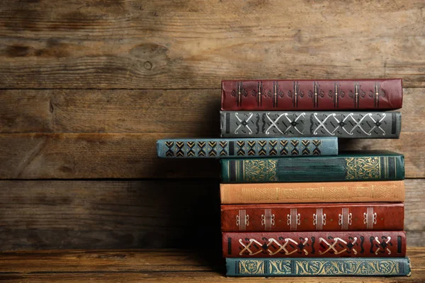 Collectie van verschillende boeken op tafel tegen houten ondergrond — Stockfoto