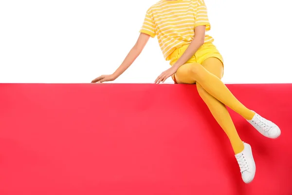 Kobieta w żółtych rajstopach siedzi na tle koloru, zbliżenie — Zdjęcie stockowe