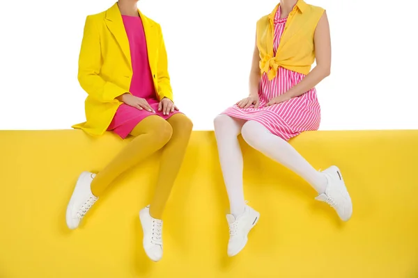 Mulheres vestindo meias brilhantes sentado no fundo de cor, close-up — Fotografia de Stock