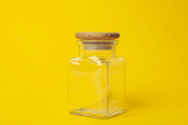 Frasco de vidro vazio fechado no fundo amarelo — Fotografia de Stock