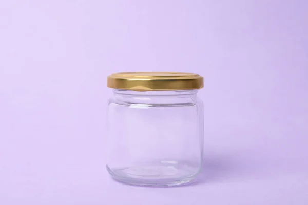 Frasco de vidrio vacío cerrado sobre fondo lila —  Fotos de Stock