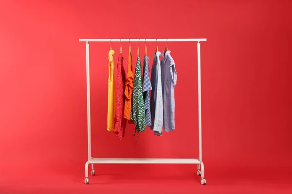 Roupas Brilhantes Penduradas Rack Contra Fundo Vermelho Cores Arco Íris — Fotografia de Stock