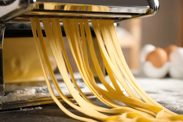 Pasta maker machine with dough on grey table, closeup — Stock Photo, Image