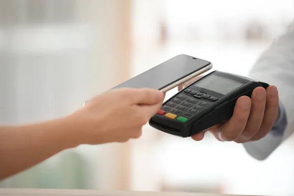 Customer using terminal for contactless payment with smartphone — Stock Photo, Image