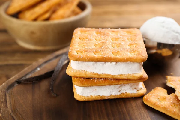 Sweet delicious ice cream cookie sandwiches on wooden board, closeup