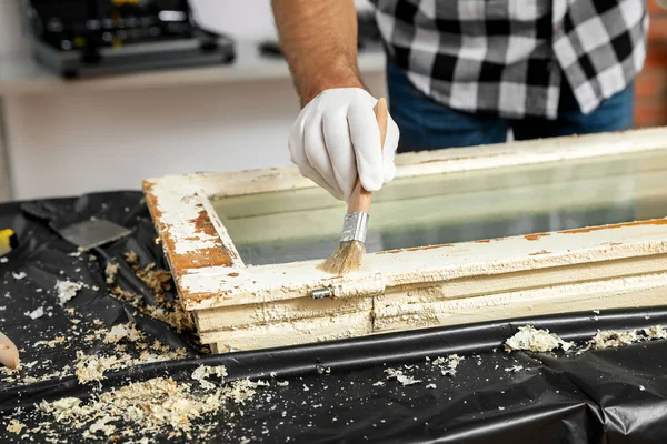 Man repareert oude beschadigde raam aan tafel binnen, close-up — Stockfoto