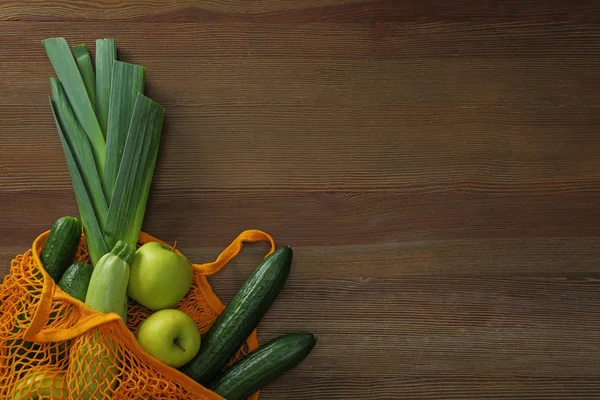 Netzbeutel mit Gemüse und Obst auf Holztisch, Draufsicht. sp — Stockfoto