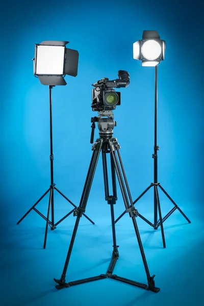 Επαγγελματική Βιντεοκάμερα Και Εξοπλισμός Φωτισμού Μπλε Φόντο — Φωτογραφία Αρχείου