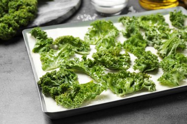 Gri masada çiğ lahana yaprakları, yakın plan. Lahana cipsi hazırlıyorum.