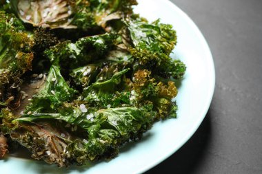 Koyu gri masada lezzetli lahana cipsleri, yakın plan.