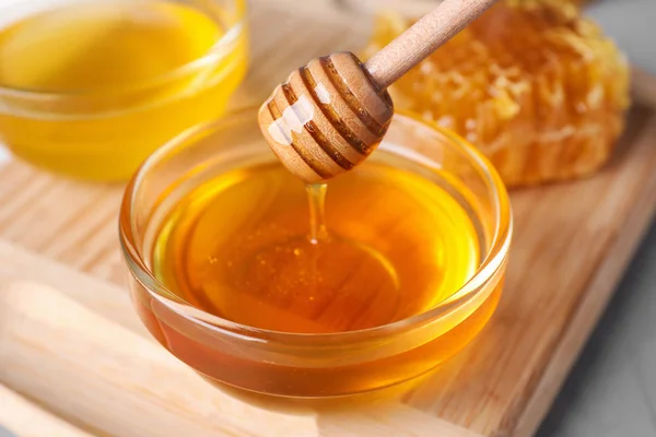テーブルの上のボウルにディップからおいしい蜂蜜を滴下 クローズアップ — ストック写真