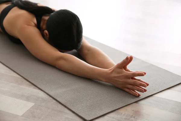 Mujer joven practicando asana de niño extendido en estudio de yoga, cl — Foto de Stock