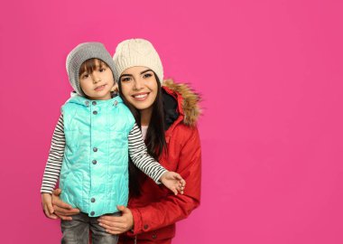 Mutlu anne ve oğul pembe arka planda kalın giysiler içinde, mesaj için yer var. Kış tatili