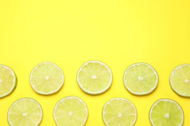 Sarı arka planda taze, sulu limon dilimleri, düz. Boşluk