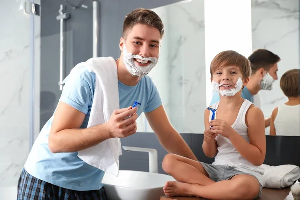 Папа и сын с пеной для бритья на лицах в ванной — стоковое фото