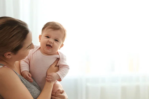 Jovem com seu bebê bonito em casa. Espaço para texto — Fotografia de Stock