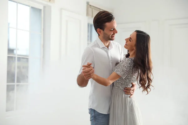 Hermosa pareja joven bailando juntos en el salón de baile. Espacio para texto — Foto de Stock