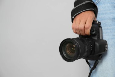 Açık gri sırtlı modern kameralı profesyonel fotoğrafçı.