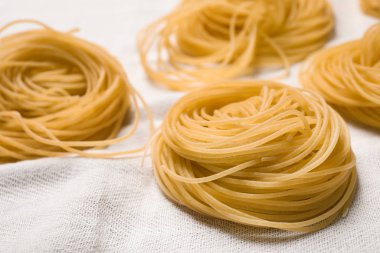 Beyaz masa örtüsü üzerinde Capellini makarnası, yakın çekim görünümü
