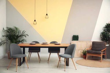 Odanın içindeki modern ahşap yemek masası.