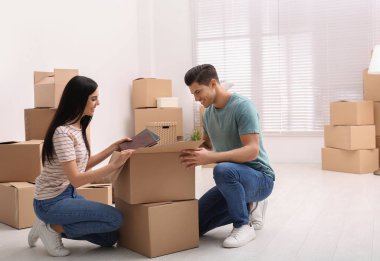 Mutlu çift, Movi 'deki yeni dairelerinde karton kutuları açıyor.