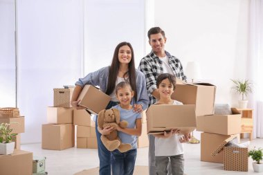 Taşındığı gün karton kutularla dolu odada mutlu bir aile.