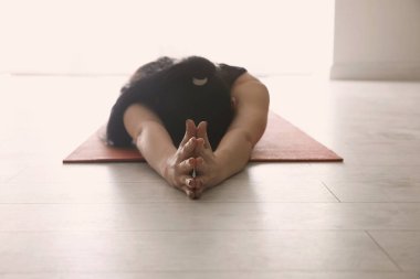 Yoga stüdyosunda rahatlama pozu veren genç bir kadın, yakın çekim.