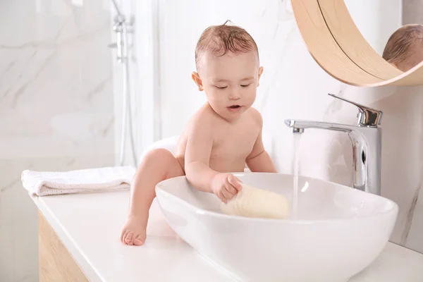 Aranyos kisbaba játszik otthon a fürdőszobában. — Stock Fotó