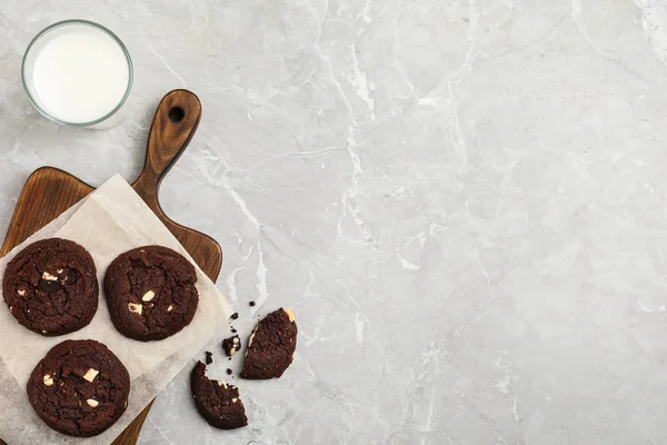 Lezzetli çikolatalı kurabiyeler ve mermer masada bir bardak süt. — Stok fotoğraf