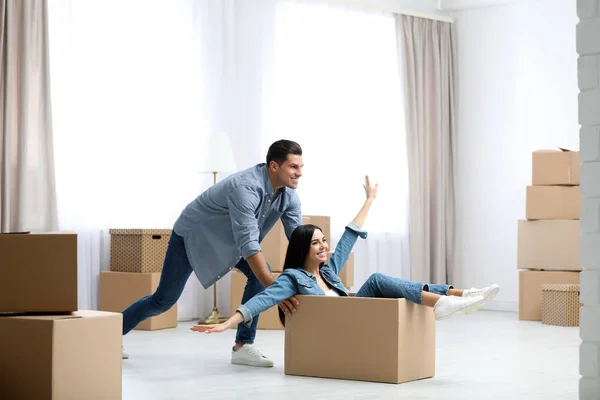 Glückliches Paar hat Spaß im Zimmer mit Pappkartons auf beweglichen d — Stockfoto