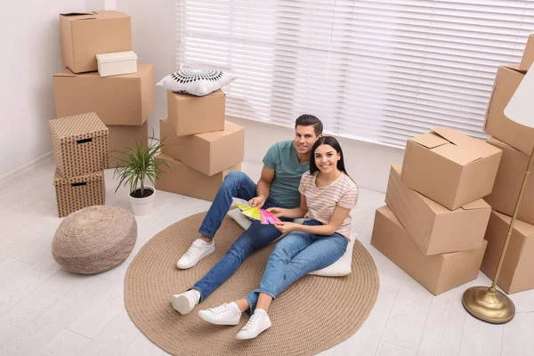 Pareja feliz con muestras de paleta de colores en su nuevo piso en mov —  Fotos de Stock