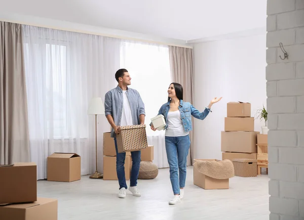 Happy couple in room with cardboard boxes on moving day — 스톡 사진